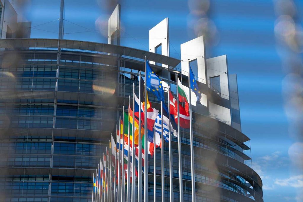 Direkttransporte Europa: Ohne Umwege ans Ziel - P.S.I. Speditions GmbH Symbolbild für Direkttransporte in Europa und der EU: Der Europa-Palast mit den europäischen Flaggen im Vordergrund